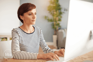 New agent at computer writing her real estate bio