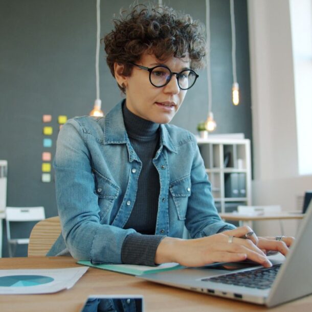 Woman at her laptop learning about how to get her real estate license with a step by step guide.